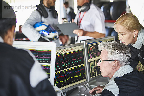 Formel-1-Team bei der Überprüfung von Diagnose-Telemetrie-Daten auf Computern