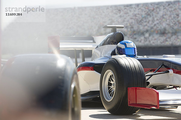 Formel-1-Rennwagen und Fahrer in der Boxengasse