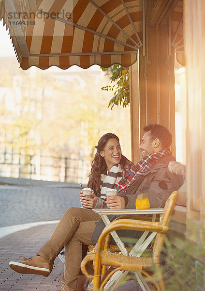 Junges Paar trinkt Milchshakes im Straßencafé