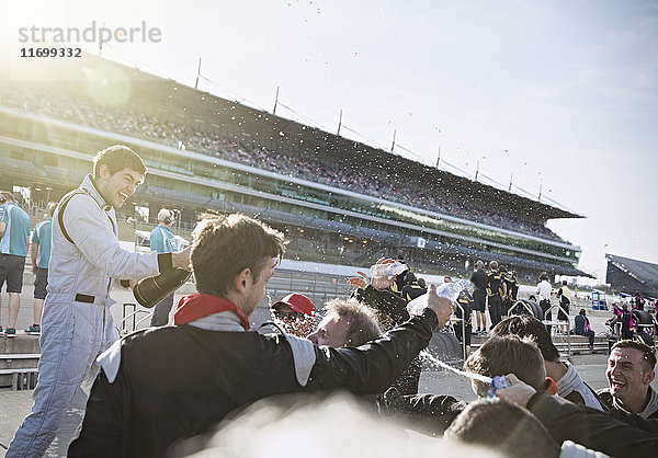 Formel-1-Rennstall und Fahrer sprühen Champagner  feiern den Sieg auf der Sportstrecke