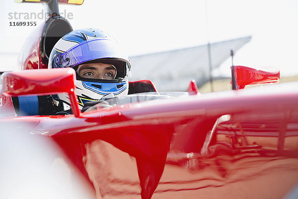 Fokussierter Formel-1-Rennwagenfahrer mit Helm  der wegschaut.