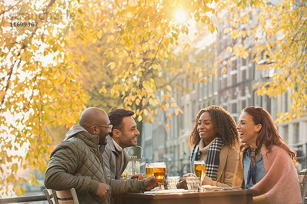 Freunde trinken Bier im Outdoor-Herbstcafé