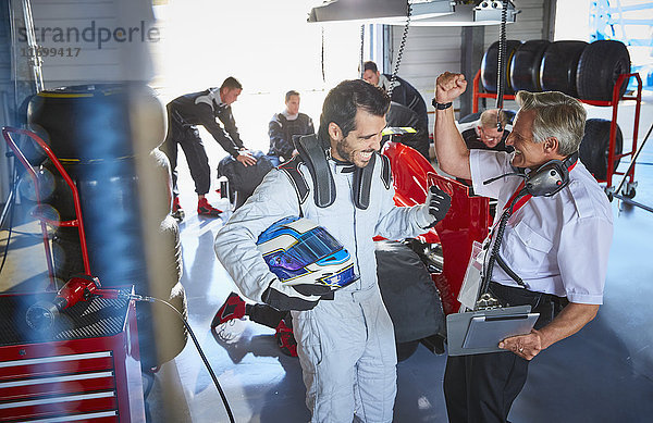 Fahrer und Formel-1-Rennfahrer jubeln  feiern Sieg in der Werkstatt