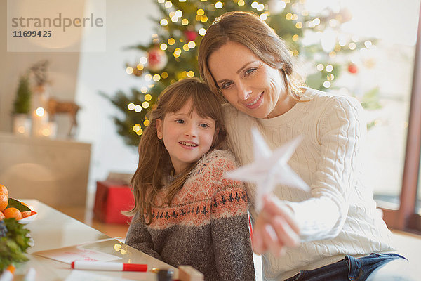 Mutter und Tochter halten Weihnachtsstern