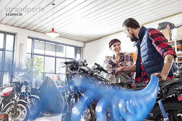 Motorradmechaniker und Motorradmechanikerinnen bei der Reparatur von Motorrädern in der Werkstatt