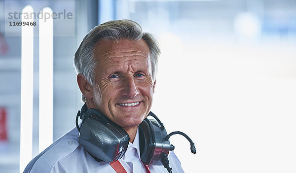 Portrait lächelnder Formel 1 Rennleiter mit Kopfhörer