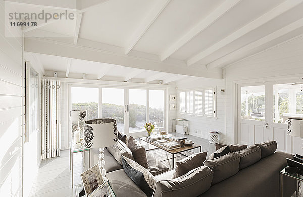 Sonniges Luxus-Wohnzimmer mit gewölbter Decke aus weißen Holzbalken