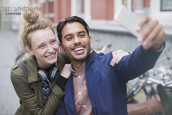 Lächelndes junges Paar macht Selfie mit Fotohandy