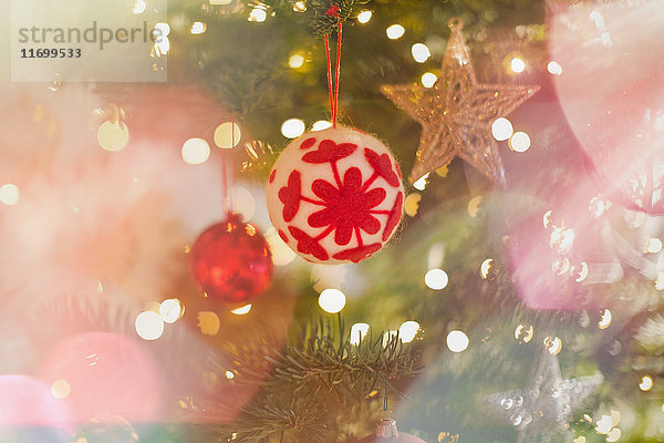 Rotes und weißes Schneeflockenornament am Weihnachtsbaum