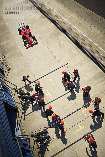 Boxencrew bereit für die Annäherung an Formel 1-Rennwagen in der Boxengasse