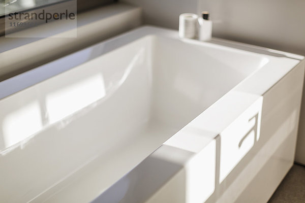 Sonnige Reflexion über moderner weißer Badewanne