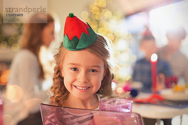 Portrait lächelndes Mädchen mit Weihnachtskrone aus Papier