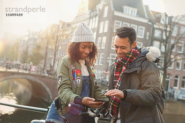 Junges Paar mit Fahrrad auf der Stadtbrücke  Amsterdam