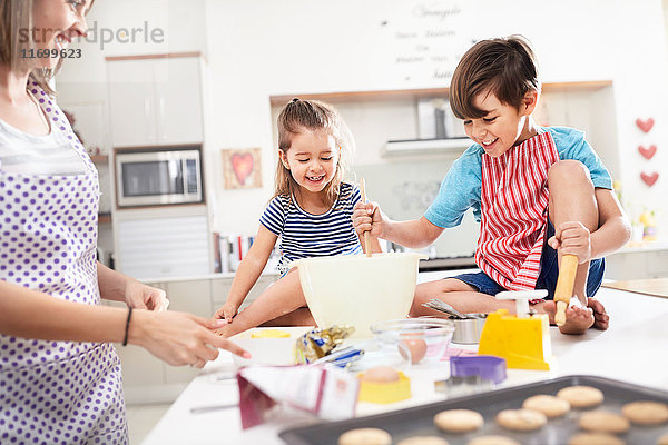 Mutter und Kinder backen Kekse in der Küche