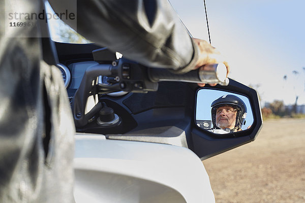 Ansicht des älteren Mannes im Seitenspiegel beim Motorradfahren