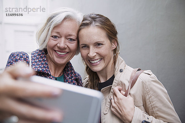 Lächelnde Mutter und Tochter nehmen Selfie mit Kamera-Handy