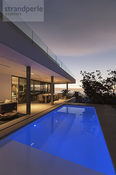 Ruhiger blauer Schoß Swimmingpool außerhalb des modernen luxuriösen Hauses Vitrine außen