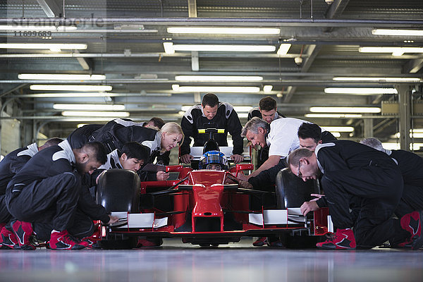 Boxencrew bereitet Formel 1-Rennwagen und Fahrer in der Reparaturwerkstatt vor