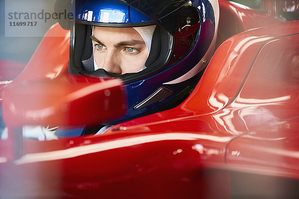 Fokussierter Formel-1-Fahrer mit Helm im Rennwagen