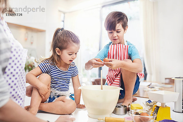 Junge und Mädchen Bruder und Schwester beim Backen auf der Küchentheke