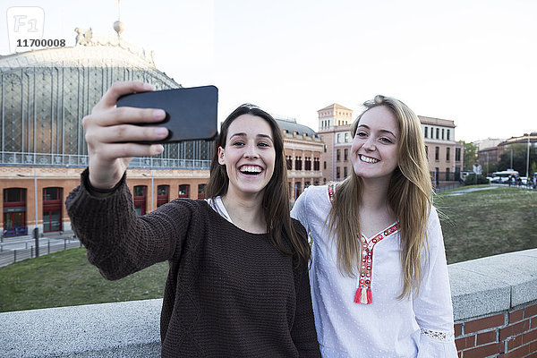 Spanien  Madrid  zwei Freunde nehmen Selfie mit Smartphone