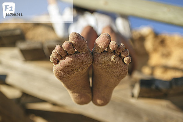 Sandige Füße der Frau am Strand