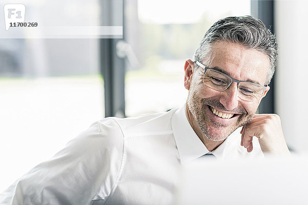 Porträt eines lächelnden Geschäftsmannes mit Stoppelbrille