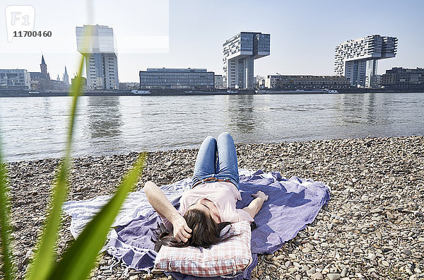 Deutschland  Köln  junge Frau entspannt am Rhein