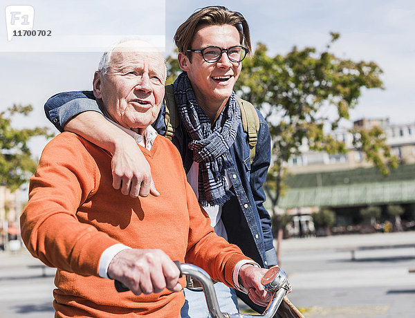 Senior Mann mit erwachsenem Enkel in der Stadt unterwegs