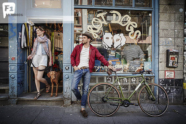 Deutschland  Hamburg  St. Pauli  Mann mit Fahrrad vor dem Vintage-Shop  Frau mit Hund im Auslauf