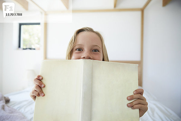 Portrait des kleinen Mädchens mit Buch zu Hause