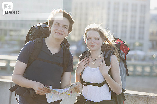 Deutschland  Berlin  Junges Paar  das mit Rucksäcken durch Berlin reist  Karte ansehen