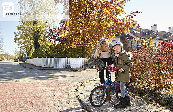 Mutter im Gespräch mit Tochter mit Fahrrad