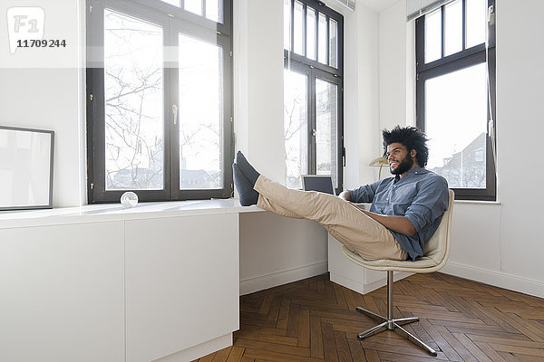Mann sitzt im minimalistischen leeren Raum auf Stuhl
