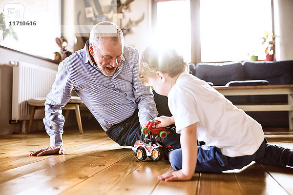 Großvater und Enkel spielen zu Hause mit Spielzeug