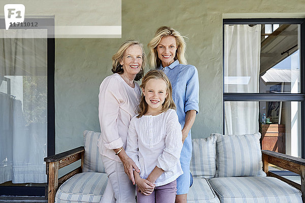 Familienbild des kleinen Mädchens mit Mutter und Großmutter auf der Terrasse