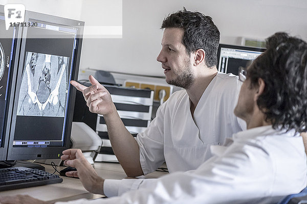 Zwei Ärzte diskutieren über das Röntgenbild am Computerbildschirm
