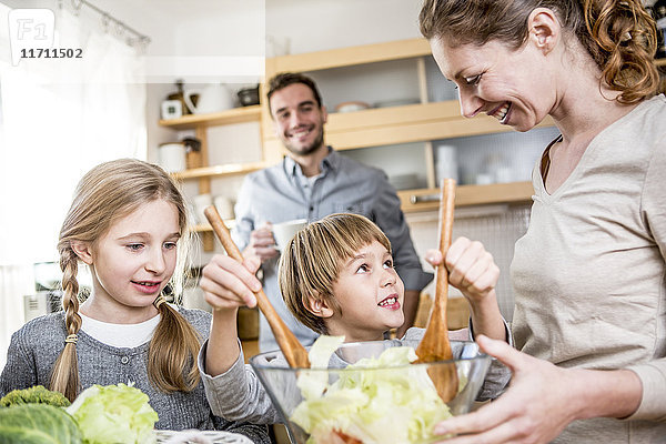 Familie bereitet Salat in der Küche zu