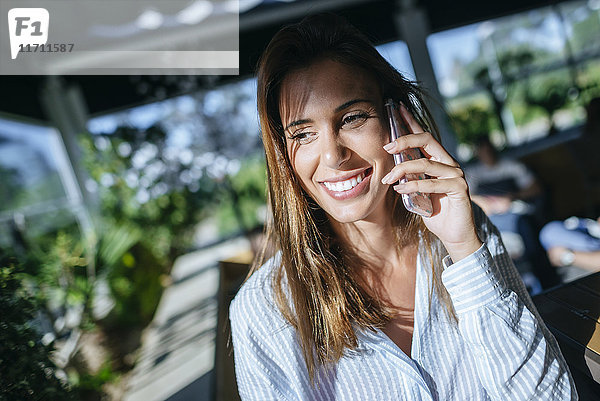 Porträt einer lächelnden Frau am Telefon
