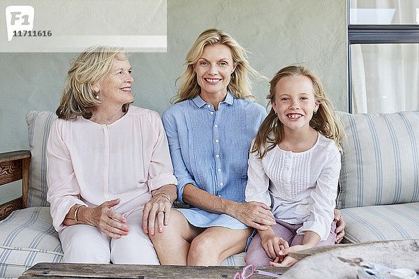 Kleines Mädchen sitzend mit Großmutter und Mutter auf der Terrasse