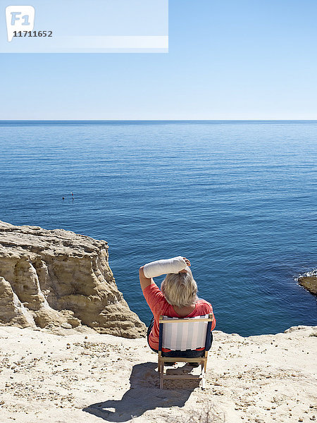 Spanien  Andalusien  Cabo de Gata  Rückansicht einer Frau mit vergipstem Arm mit Blick aufs Meer