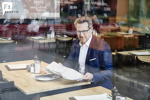 Reife Geschäftsleute im Cafe lesen Zeitung