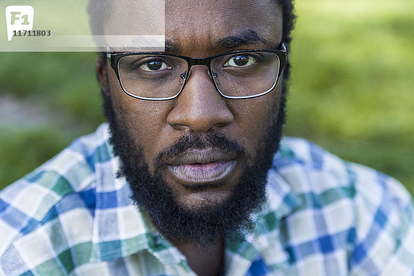 Porträt eines ernsthaft aussehenden Mannes mit Bart und Brille