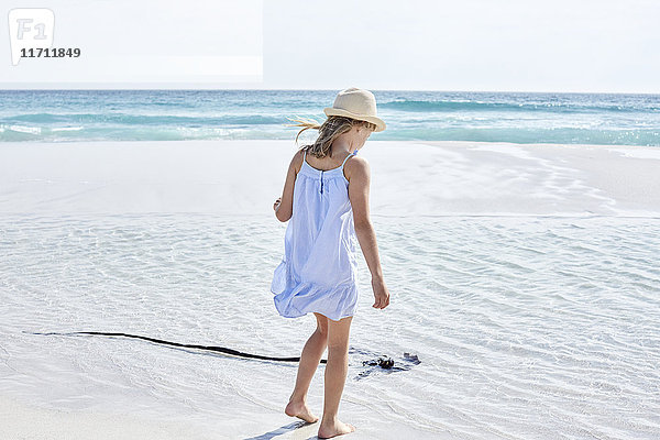 Kleines Mädchen  das am Strand spazieren geht.