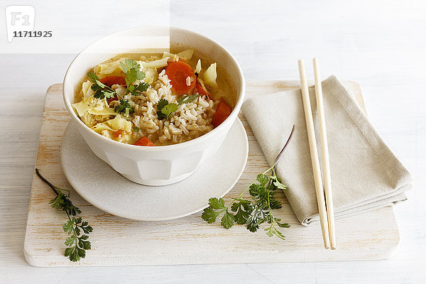 Schüssel mit asiatischer Suppe mit Weißkohl  Karotten und Reis