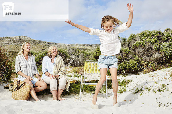 Mutter  Tochter und Großmutter verbringen einen Tag am Strand  Mädchen springen vor Freude
