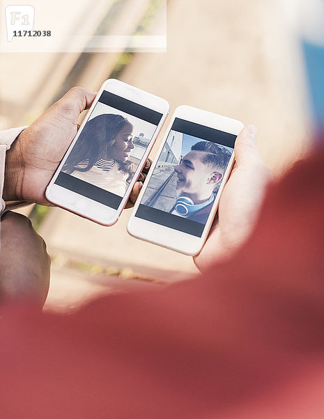 Hände halten Smartphones mit Bildern eines jungen Paares