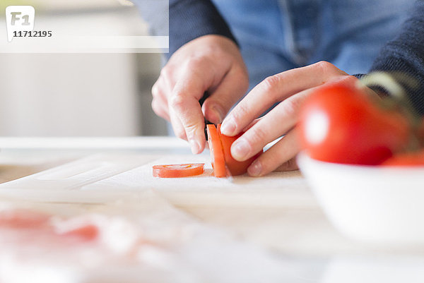 Männerhände beim Tomatenhacken