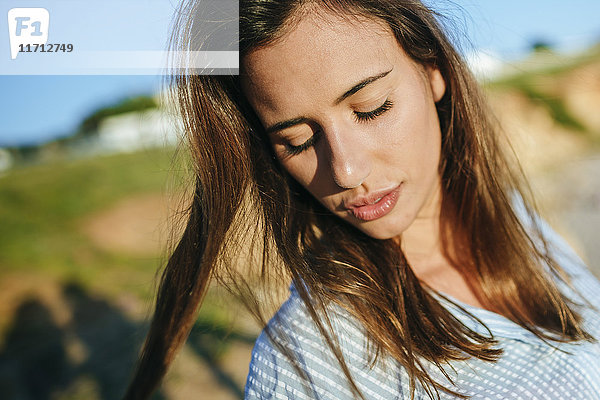 Porträt einer jungen Frau mit geschlossenen Augen bei Sonnenlicht