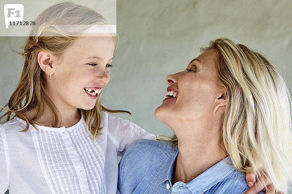 Lachendes kleines Mädchen von Angesicht zu Angesicht mit ihrer Mutter